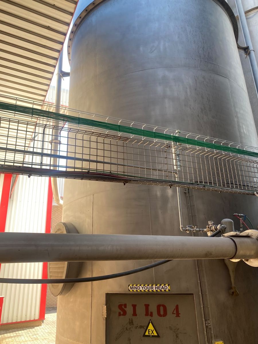 Cable tray routed past industrial silos