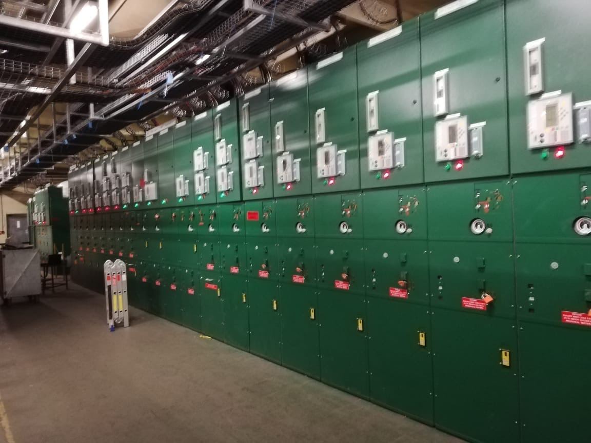 Row of medium-voltage switchgear panels in a plant switch room